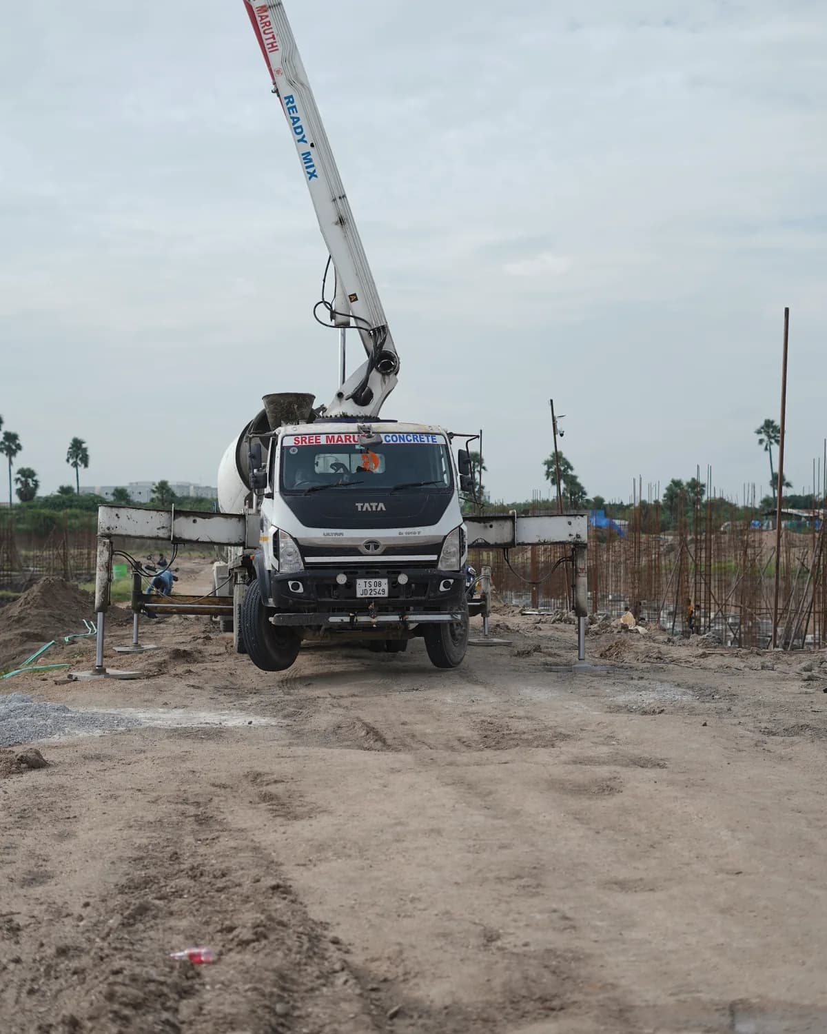 Concrete pump truck parked at the edge of the Golden Villas foundation works